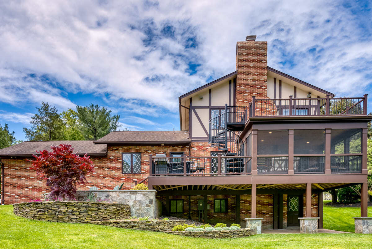 Multi-level outdoor living space with porch, deck, and patio by Deckscapes of VA