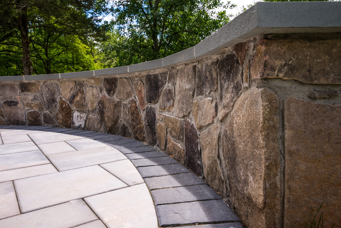 Curved stone patio seating wall by Deckscapes of Virginia