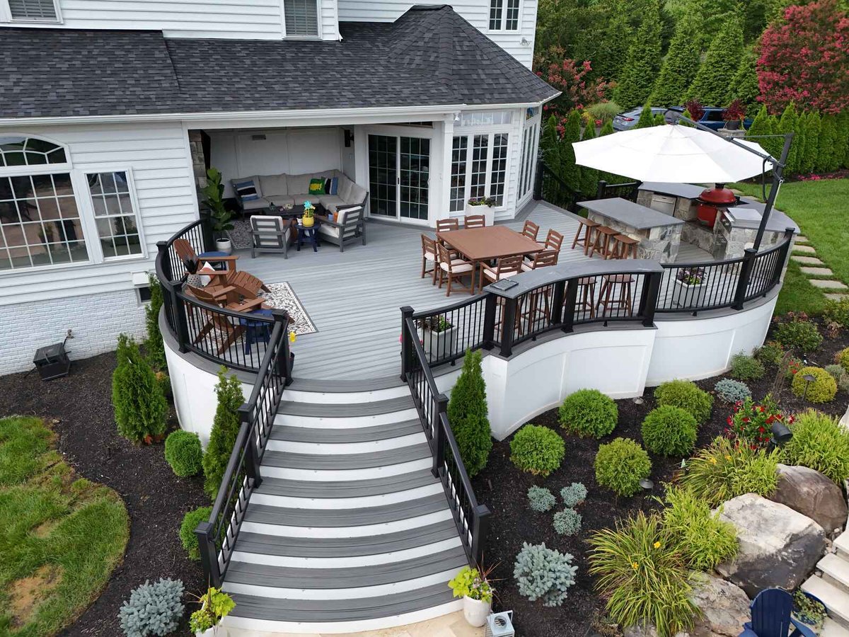 Drone view of round deck with dining, lounging, and barbecue area, designed by Deckscapes of Virginia
