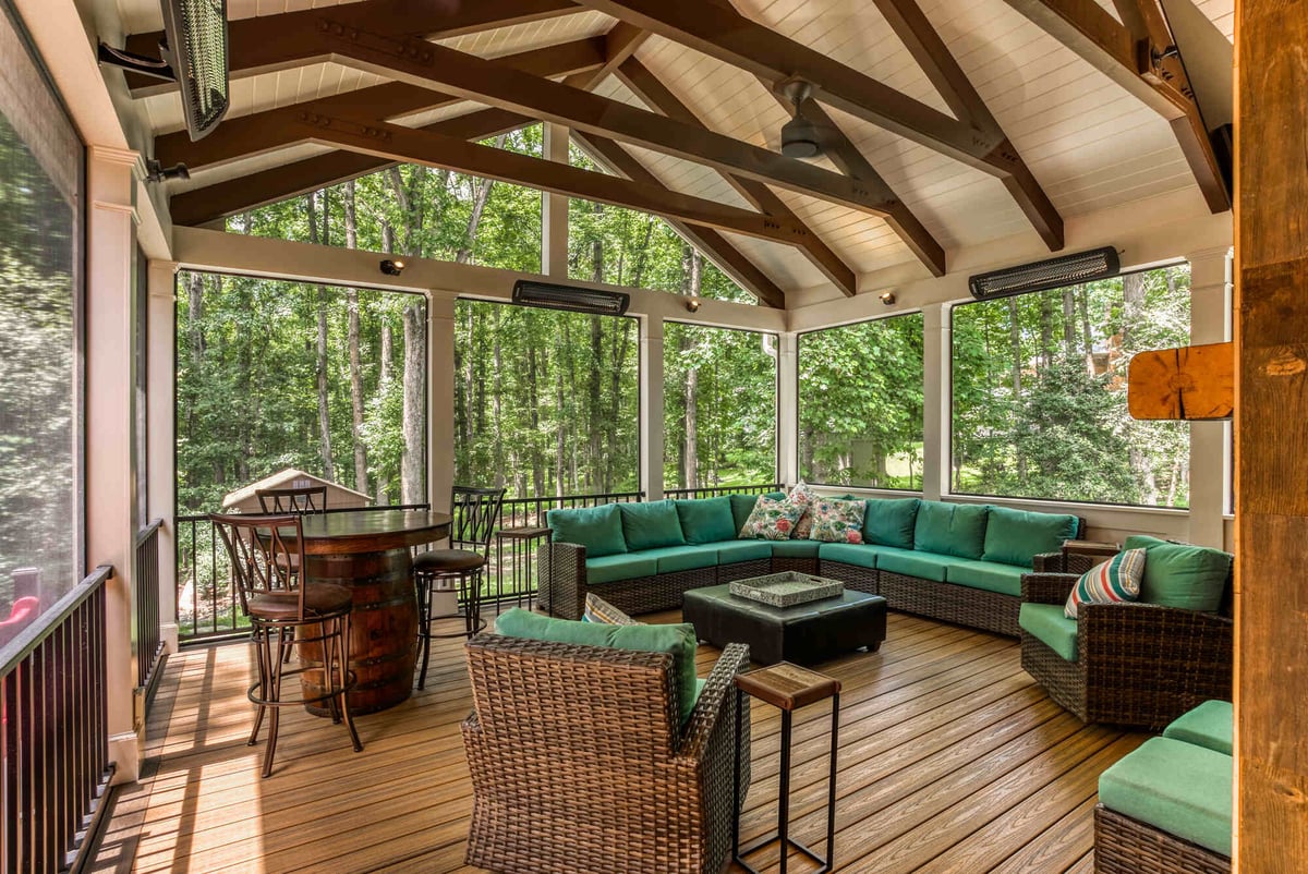 beamed ceiling screened in porch with patio furniture and bar table